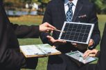 Outdoor business meeting on solar energy, group of business people working and brainstorming on alternative energy technology utilization as corporate commitment to CSR effort. Gyre
