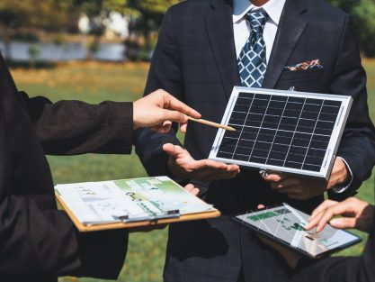 Outdoor business meeting on solar energy, group of business people working and brainstorming on alternative energy technology utilization as corporate commitment to CSR effort. Gyre
