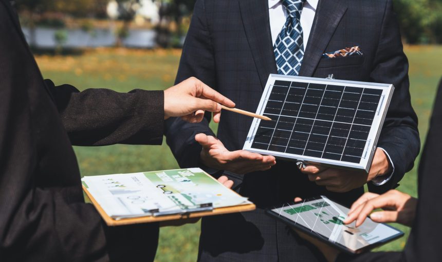 Outdoor business meeting on solar energy, group of business people working and brainstorming on alternative energy technology utilization as corporate commitment to CSR effort. Gyre