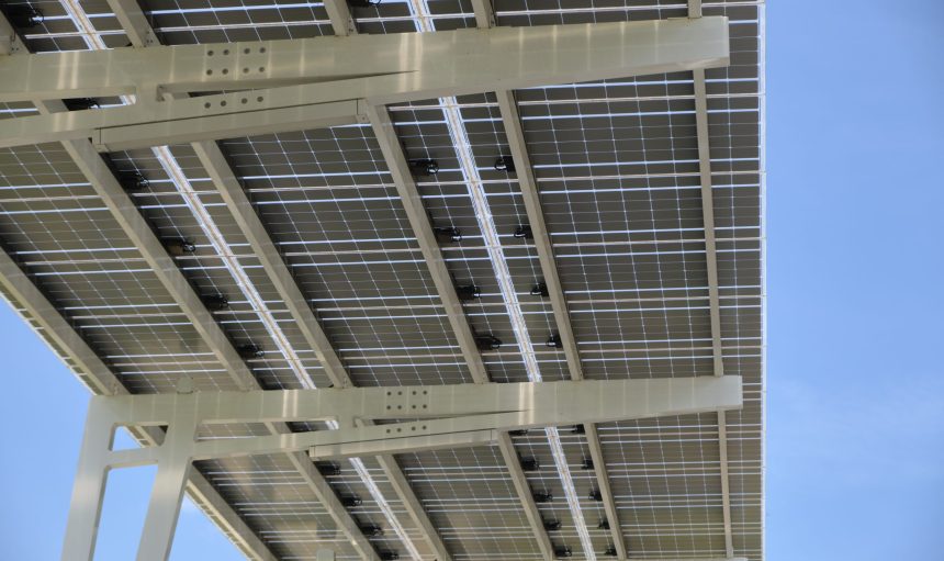 Solar panels installed over parking lot canopy shade for parked cars for effective generation of clean energy.