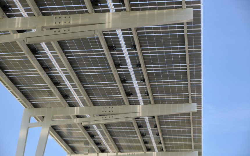 Solar panels installed over parking lot canopy shade for parked cars for effective generation of clean energy.